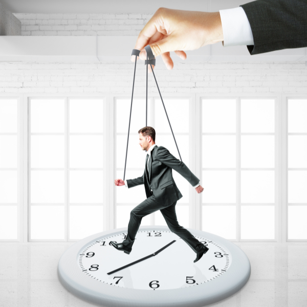 a person in business attired holding strings on a businessman running on a clock, what is workaholism, iMind Mental Health Solutions