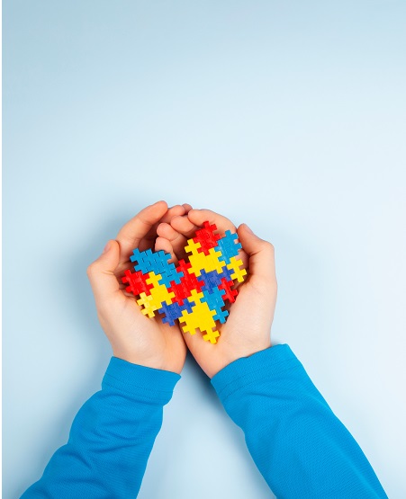 young-childs-arms-holding-a-multicolored-puzzle-in-the-shape-of-a-heart-autism-treatment-iMind-Mental-Health-Solutions