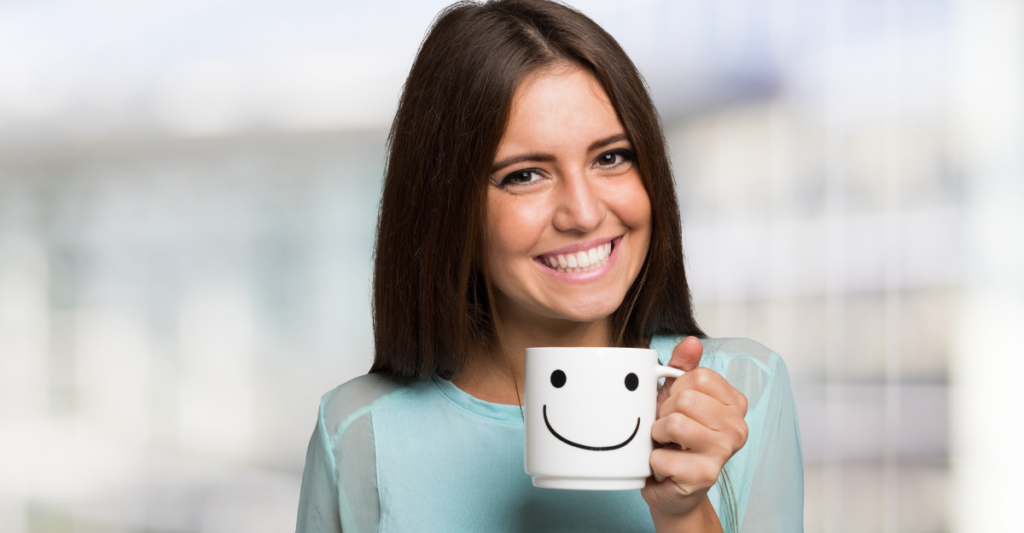 woman-smiling-holding-a-coffee-cup-with-a-smiley-face-on-it-does-cognitive-behavioral-therapy-work-iMind-Mental-Health-Solutions.