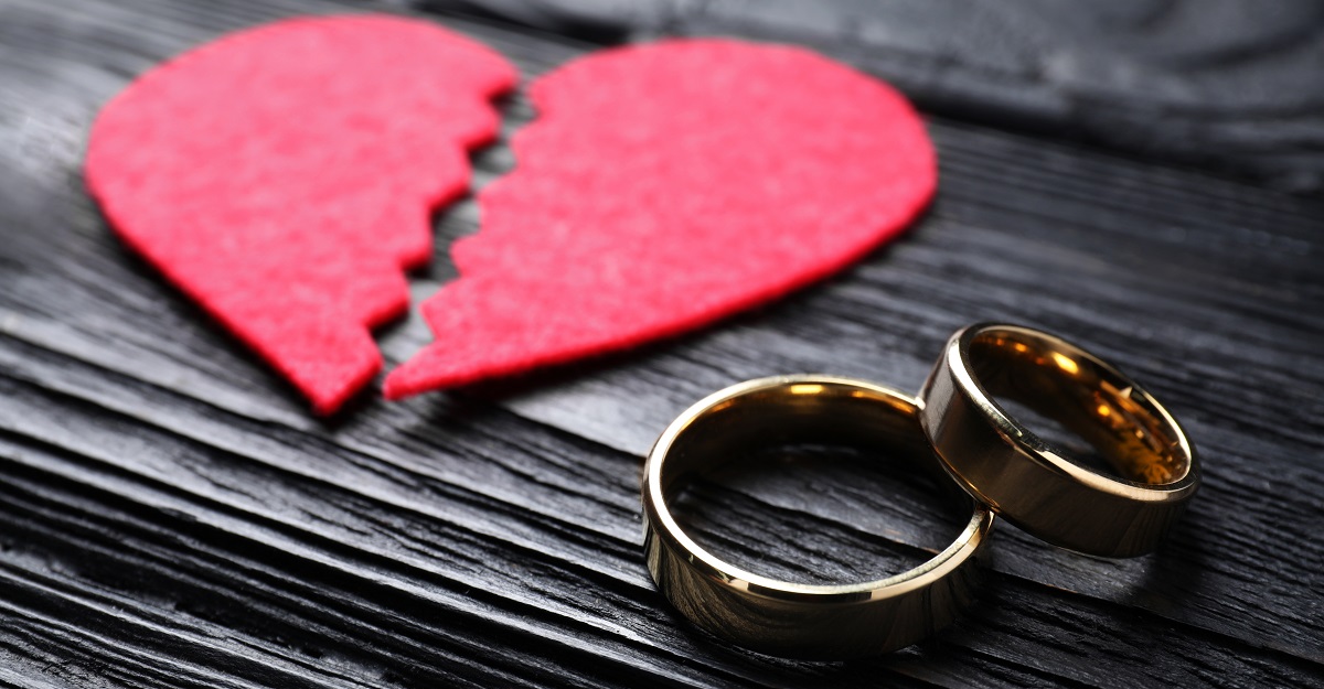 two-gold-wedding-rings-stacked-on-top-of-each-other-with-a-broken-heart-shaped-paper-creation-behind-and-to-the-side-of-them-when-you-dont-want-the-divorce-iMind-Mental-Health-Solutions