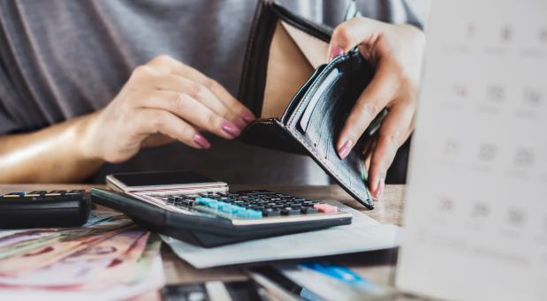 hands-holding-an-open-and-empty-wallet-on-top-of-a-desk-with-a-calculator-why-is-everybody-depressed-iMind-Mental-Health-Solutions-