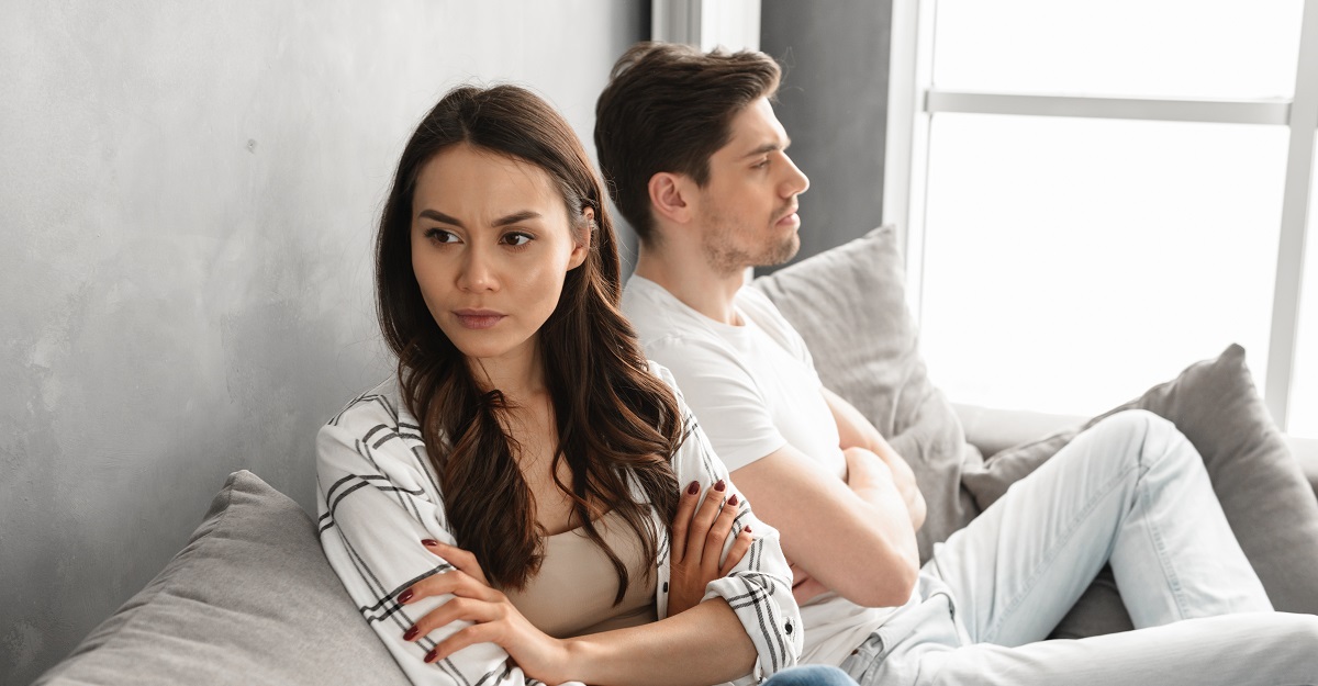couple-sitting-on-couch-with-arms-crossed-and-facing-away-from-each-other-are-we-overusing-the-term-passive-aggressive-iMind-Mental-Health-Solutions