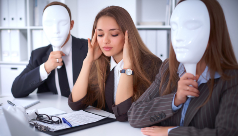 business-woman-sitting-at-a-conference-table-between-two-people-holding-white-masks-over-their-faces-how-to-spot-a-toxic-workplace-before-you-start-iMind-Mental-Health-Solutions