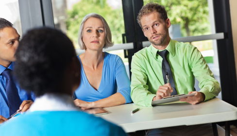 two-business-people-looking-at-a-job-candidate-with-a-third-on-their-side-of-the-table-looking-on-how-to-spot-a-toxic-workplace-before-you-start-iMind-Mental-Health-Solutions