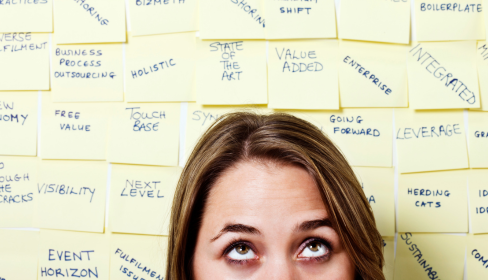 women-standing-against-a-wall-of-stickie-notes-with-jargon-such-as-integrated-holisitic-business-process-outsourcing-event-horizon-touch-base-and-more-how-to-spot-a-toxic-workplace-befo